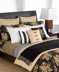 A made bed with black, brown and orange fabric.