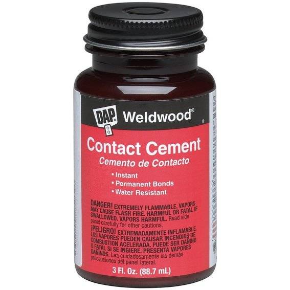 A container of contact cement with a red label.