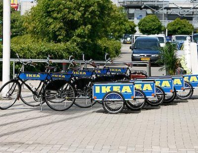 A series of ikea bikes lined up in the parking lot.