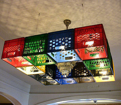A chandelier is surrounded by colorful milk crates to make a unique light fixture.