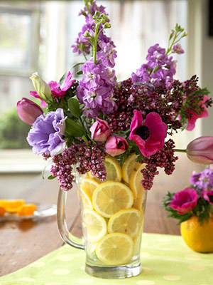 A glass flower vase that looks like it is full of lemons.