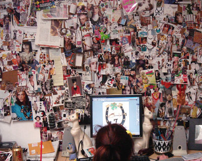 A woman looks at her laptop against a backdrop of dozens of collaged photos.