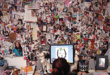 A woman looks at her laptop against a backdrop of dozens of collaged photos.