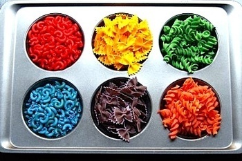 A baking pan with many different colored pasta noodles.