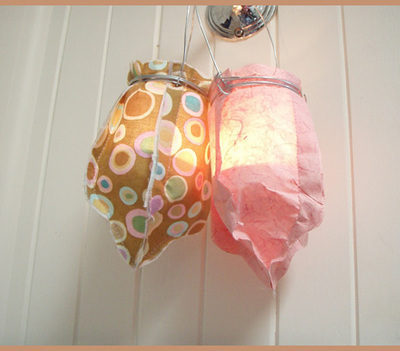 Two colorful light up balloons hanging from a doorknob.