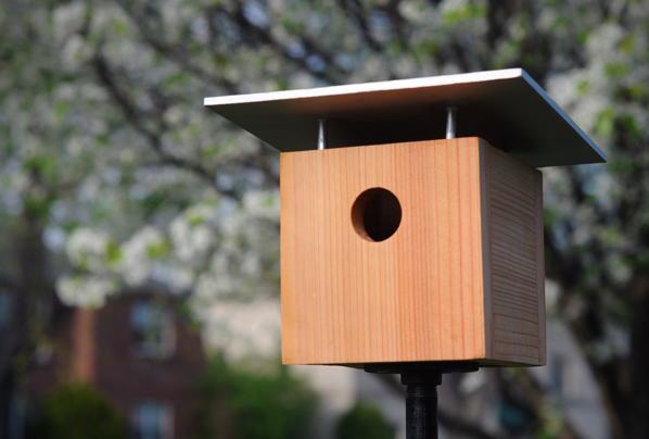 A birdhouse made out of wood with a roof.