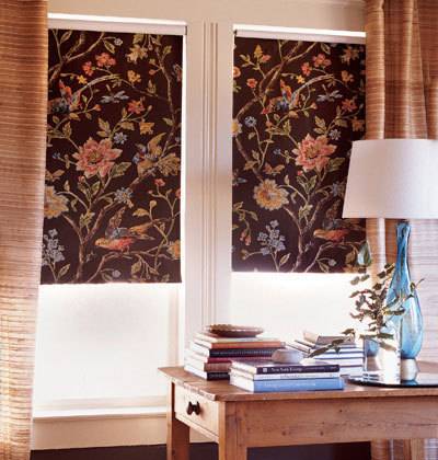 Floral blinds cover the windows in a room with a desk.