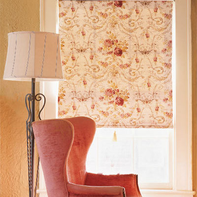 A red arm chair near a tall lamp.