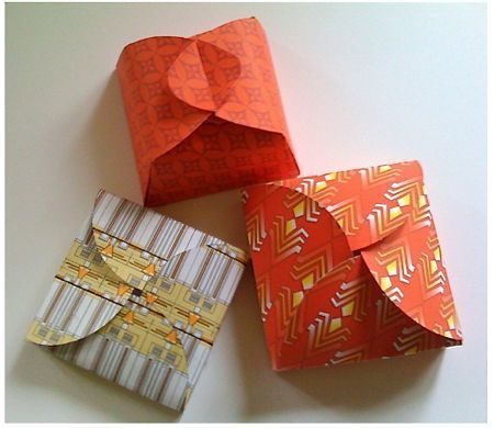 Three to-go boxes are closed with different paper folding techniques.