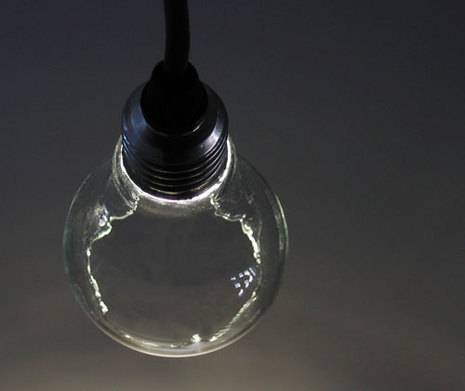 A light bulb is connected to a black plug.