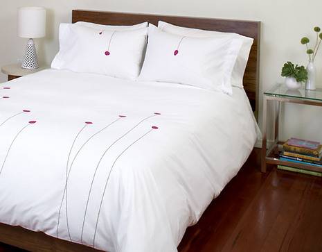 A white background with black and red poppies decorates matching bedding.