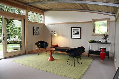 A front patio room it's fully enclosed with a green throw rug.
