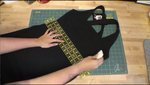 A black dress being designed on a table.