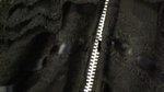 A silver zipper between black material.