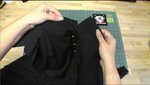 A person is using black material to make a shirt.