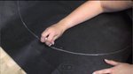 A person's arm drawing a white circle on a black cloth.
