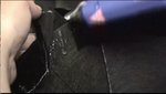 A person uses a crafting tool on black fabric.