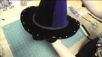 A black witches hat on top of green fabric.