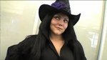 A woman in a black shirt and purple witch hat.
