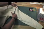 A tailor cutting the pant using scissors
