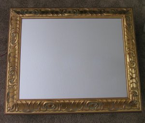 A blank canvas framed in a gold bordered frame.