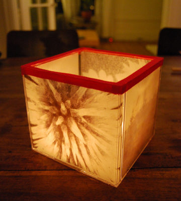 A small glowing box of cream and amber color on a wooden table.