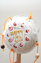 A white balloon made from paper plates that says happy new year.