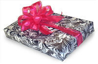 A wrapped present with swirly black and white paper and a red pink bow.