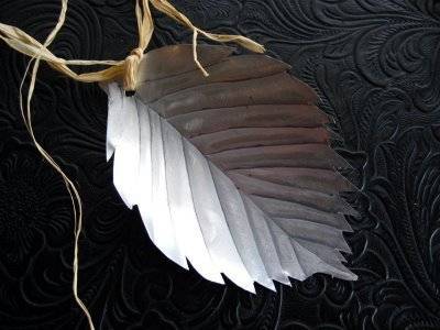 A broad white leaf ornament has a grass hanging loop.