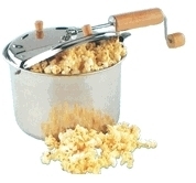 Stovetop popcorn maker with popcorn overflowing from the top.