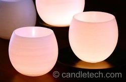 Frosted glass containers with lights inside sit next to each other.