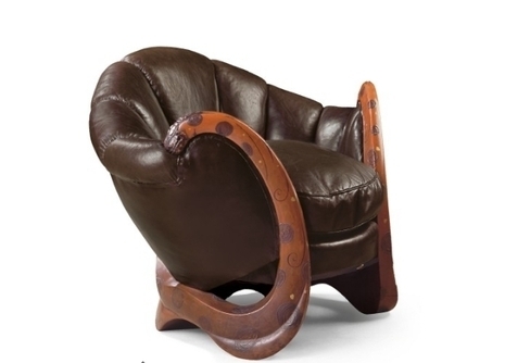 A brown leather chair with interesting wooden arm rests.