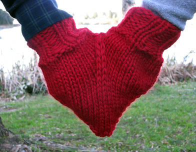 Two  red gloves sewn together to make a heart.