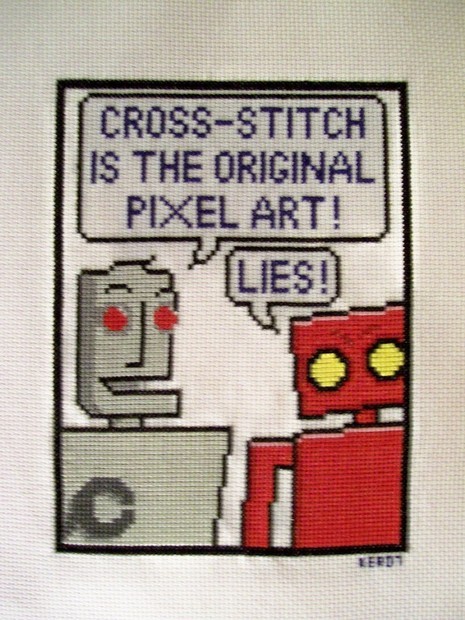 Cross-stitch picture of robots talking to each other.