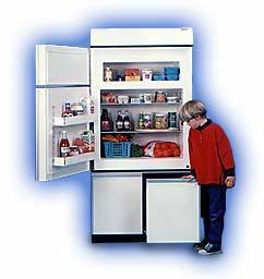 A boy in a red sweater looking at a full fridge that is open.