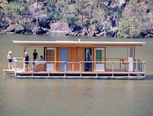 Group of people in house boat on a lake.