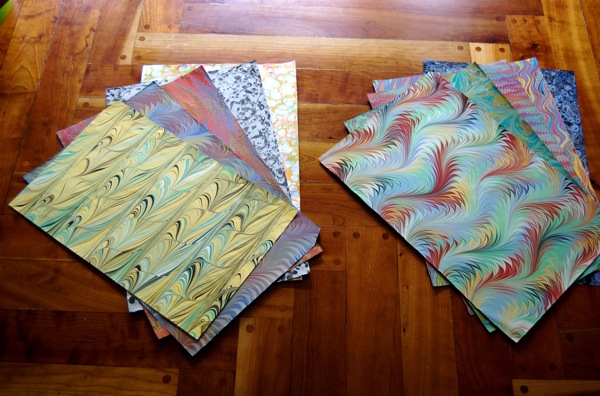 Colorful marble papers are on wooden floor.