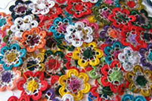 Colorful craft flowers made from pull tabs sit in a pile.