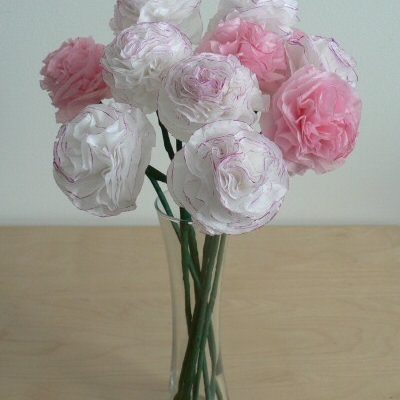 Dark pink and light pink paper carnations in a clear vase.