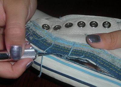 A woman is attempting to repair her badly damaged sneakers.