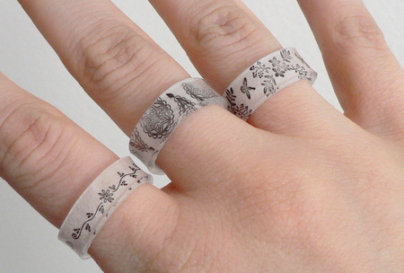 A hand displays three rings made of shrinky dinks.
