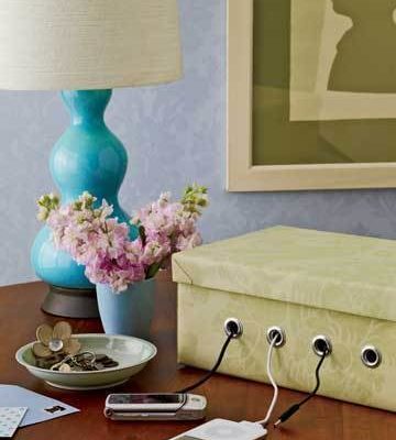 A decorated shoebox turned into a portable electronic device cord keeper.