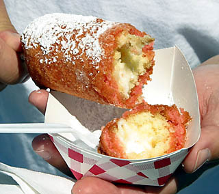 Person holding a tray of fried cake batter or butter.