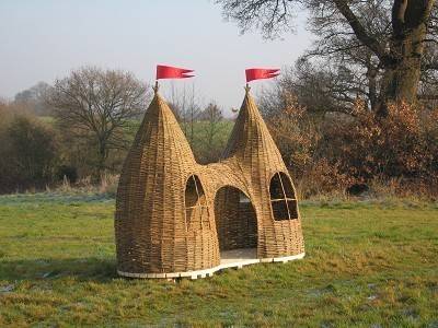 A child's playhouse made of woven willow branches.