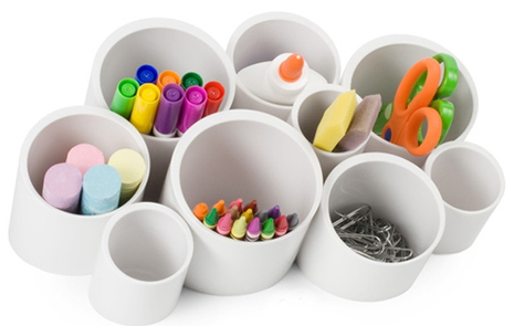 Paperclips, crayons, scissors, markers, chalk, glue are in cups designed to hold office supplies.