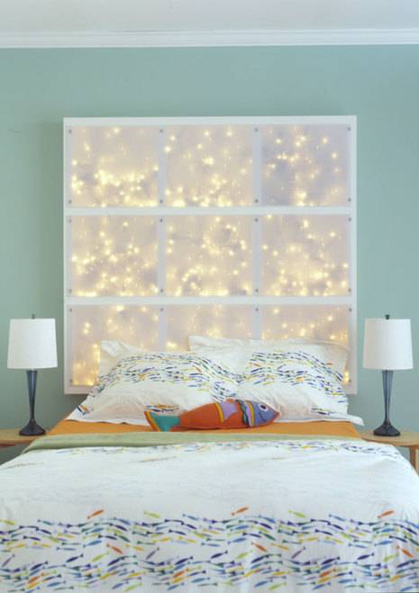 Large soft box with lights behind a bed, acting as a headboard.