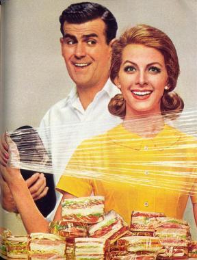 A happy couple with plastic in front of pieces of cake.
