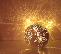 Decorative light globe turned on and shining on the wall.