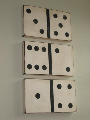 Six Domino's made of wood are mounted on a wall.