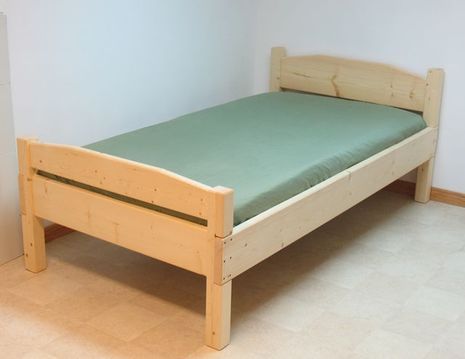 Single bed with a wood frame, and a green mattress.